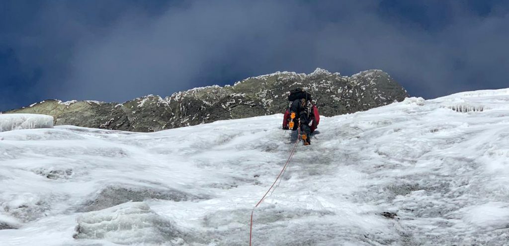 A climber hiking to the top of Rwenzori Mountain, with the skies showing the best time to hike Rwenzori Mountain. Credit: Sima Safari